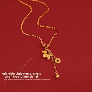 Detail of a gold horse pendant necklace with a coin charm on a deep red texture