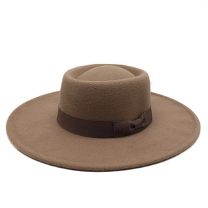 Close-up of brown wool felt wide-brim fedora hat with elegant ribbon bow detail