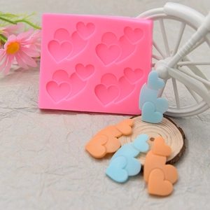 Dettaglio dello stampo in silicone a 4 cuori con forme di cuore in fondente colorato
