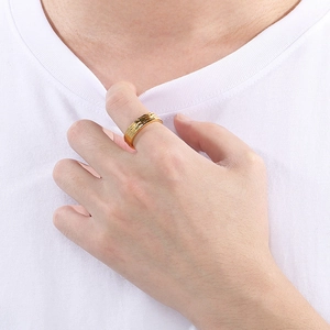 Detail of gold hammered texture stainless steel ring worn on index finger for men