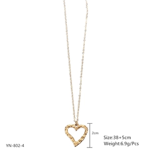 Détails d'un pendentif cœur doré à texture martelée et indications de dimensions