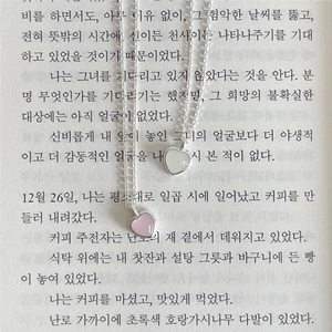 Elegant 925 sterling silver heart crystal necklaces in pink and white on a book