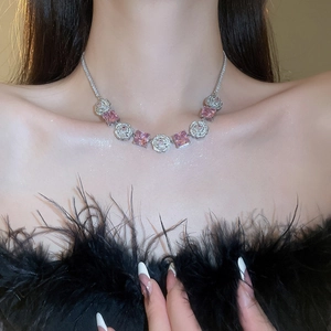 Detail of pink zircon flower choker necklace on model with black feather outfit