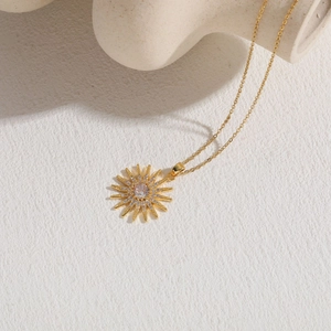 Detailed view of sunburst zircon pendant with 14K gold plating and sparkling gemstones