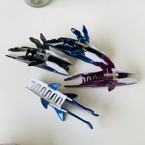 Close-up of ocean-themed whale and shark acetate hair claws in various vibrant colors