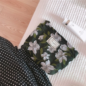 Detailed close-up of dark green floral embroidery canvas makeup bag with zipper closure