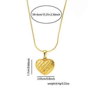 Detail of a textured golden heart pendant with dimensions 2.05x1.7cm on a white background
