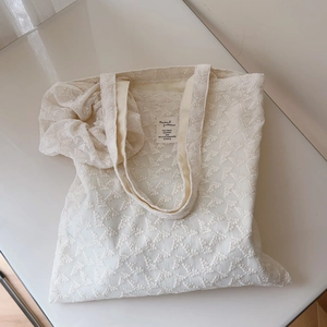 Detailed embroidery texture and interior brand label on the vintage lace tote bag