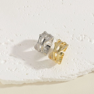 Gold and silver bamboo style rings with pavé cubic zirconia on textured stone background