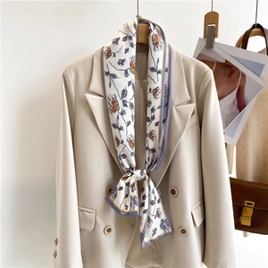 Floral print long silk scarf styled on a beige blazer with purple and orange flower patterns