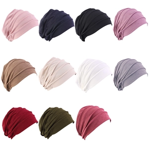 Flat lay display of pleated headwraps in eleven different colors for chemo or sleeping
