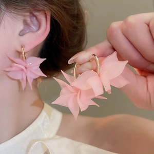 Detail of pink frosted acrylic petal earrings with elegant golden metal hoops for women