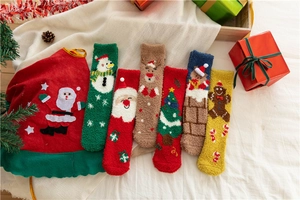 Detail view of colorful coral fleece Christmas socks set with gift bag and festive decor