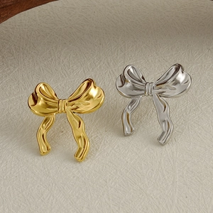 Close-up of stylish gold and silver ribbon bow earrings in 304 stainless steel