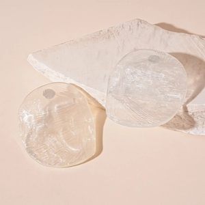 Macro view of translucent resin stud earrings with irregular shape and crackle texture
