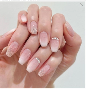 Close-up of pink gradient press-on nails with silver glitter and rhinestone accents