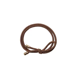 Elastic braided hair tie in dark brown with two elegant gold-tone metallic buckle accents