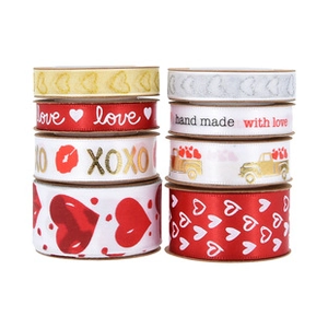 Detail of 8 rolls of heart-themed satin ribbons in red and gold for gift wrapping