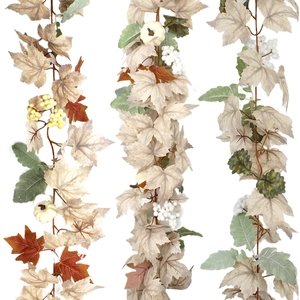 Detail of autumn garland with white pumpkins, maple leaves, and berries on white backdrop