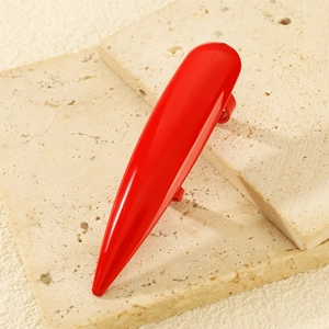 Anillo de uña larga garra en rojo brillante sobre una superficie de piedra travertino