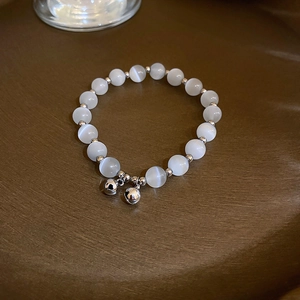 Elegant gold-plated bamboo bracelet with cat-eye beads and delicate metal bell charms