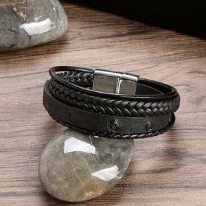 Detail of multi-layer black braided leather bracelet with silver magnetic metal clasp