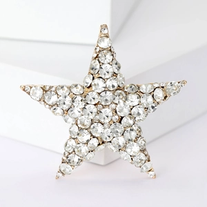Detailed macro view of a gold five-pointed star brooch with sparkling crystals
