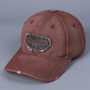 Dettaglio del ricamo D.daisy e dell'effetto invecchiato sul cappello di jeans rosso