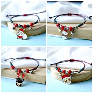 Detail of four handmade Christmas braided bracelets with enamel Santa and snowman charms
