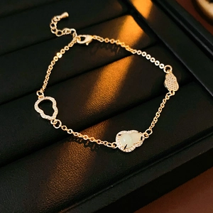 Macro detail of 18K gold hollow gourd bracelet with green jade and pavé zircon stones