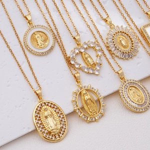 Gold Virgin Mary necklaces with zircon pendants in various shapes on stone display