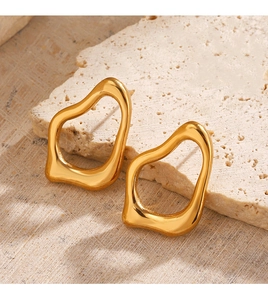 Dettaglio di orecchini irregolari geometrici placcati in oro 18 carati su pietra
