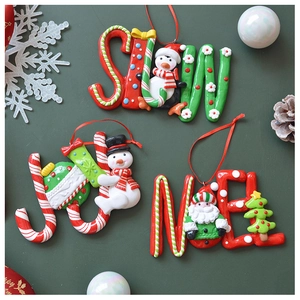 Detail showing festive SNOW, JOY, and NOEL clay ornaments with holiday characters