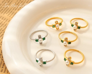 Detailed close-up of Baroque pearl rings with rhinestones on a white ceramic tray