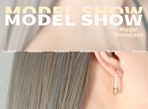 Detail shot of a golden paperclip earring with pearls worn by a model in French retro style