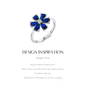 Macro detail of S925 sterling silver ring featuring a blue sapphire flower and engraving