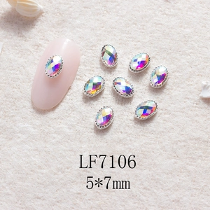 Détail macro de charmes d'ongles ovales AB irisés 5x7mm avec bordure en métal argenté