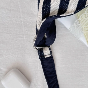 Détail du sac en toile rayé montrant les anneaux métalliques et la texture tissée épaisse