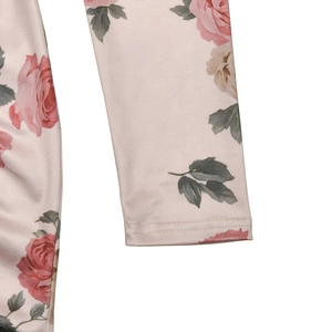 Close-up of pink rose floral print and stitching detail on a long sleeve dress
