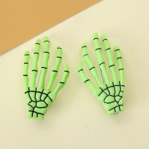 Detail of neon green skeleton hand hair clips with black bone structure for Halloween