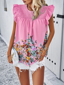 Detail of pink floral sleeveless top featuring ruffled shoulders and smocked bodice design