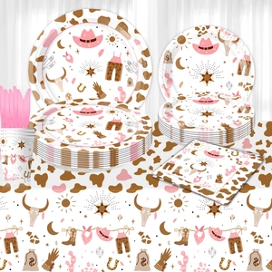 Pink cowgirl western party supplies set with cow print plates, cups, and napkins