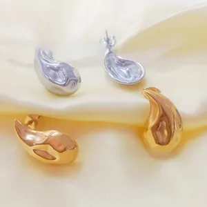 Detail view of waterdrop earrings in silver and gold plating on satin fabric