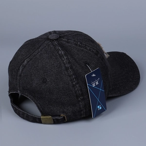 Dettaglio del cappello da baseball in denim nero vintage con fibbia in metallo e targhetta