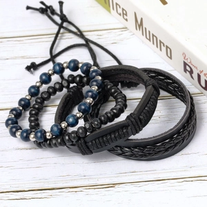 Set of four vintage multilayer leather bracelets with black and blue beads on wood