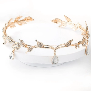 Detail of golden leaf bridal crown with sparkling crystal teardrop pendants on white base