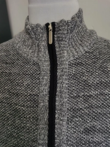 Close-up detail of knitted sweater with stand-up collar and smooth metal zipper