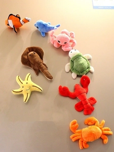 Collection of eight colorful plush sea animal magnets including clownfish and dolphin