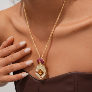 Gros plan détaillé d'un pendentif bouclier doré vintage avec ambre et cristaux colorés