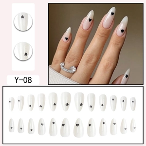 Almond shaped press-on nails with white base and black heart patterns 24-piece set